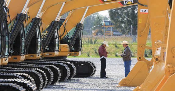 Potential buyers inspecting excavators in Mexico